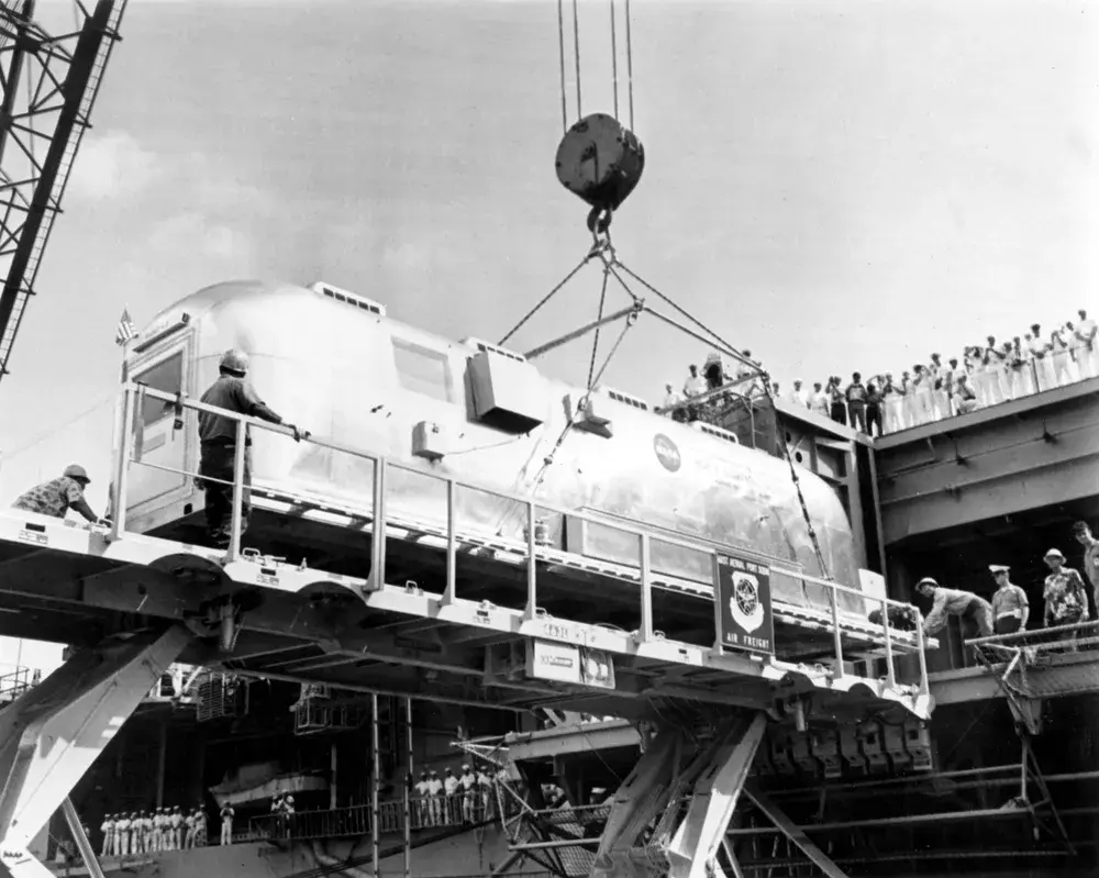 アポロ11号の宇宙飛行士が月から帰還後に隔離された移送モジュール(MQF)が、艦船に積み込まれている様子。万が一のウイルス感染に備えた厳重な体制が敷かれていた。