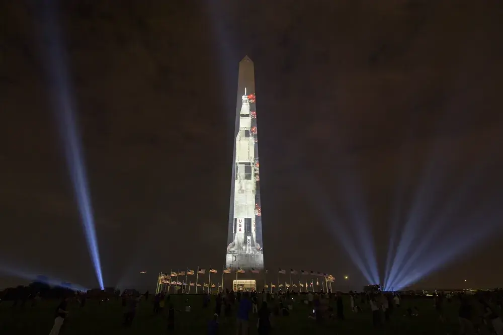 サターンVロケットが、アメリカ・ワシントン記念塔に投影されている夜の風景。アポロ11号の月面着陸50周年を記念したNASAのプロジェクションイベント。